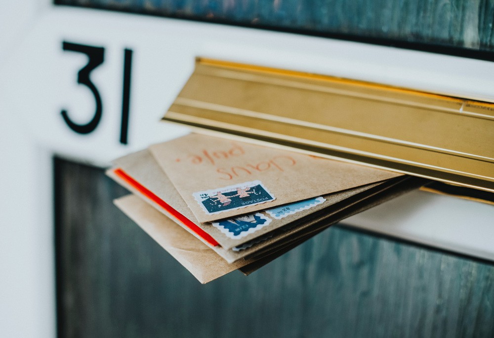 fotografía de 3 cartas que salen de un buzón de correo